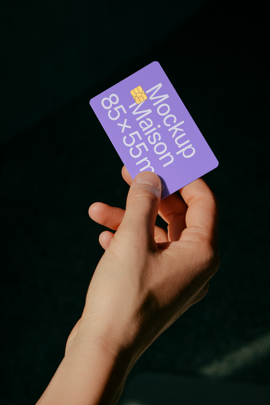PSD mockup of a purple card labeled "Mockup Maison 85x55 mm" held between a thumb and fingers against a dark background.