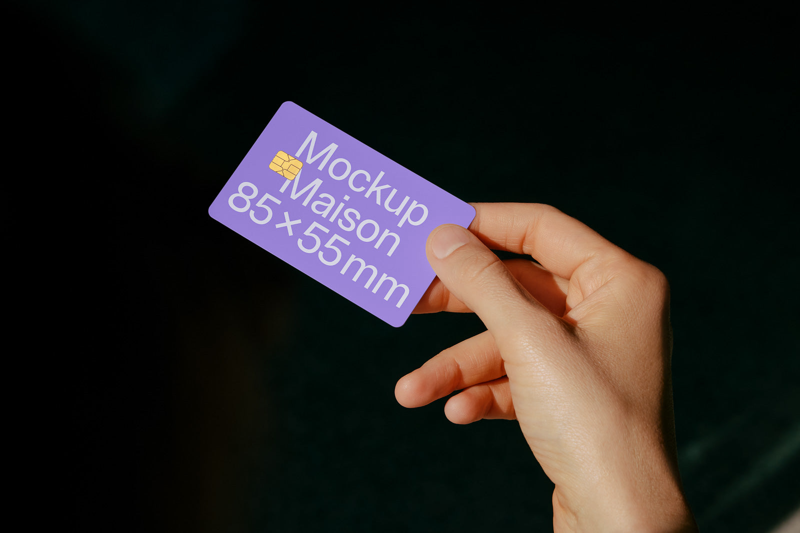 PSD mockup of a hand holding a purple card labeled "Mockup Maison 85x55mm" against a dark background.