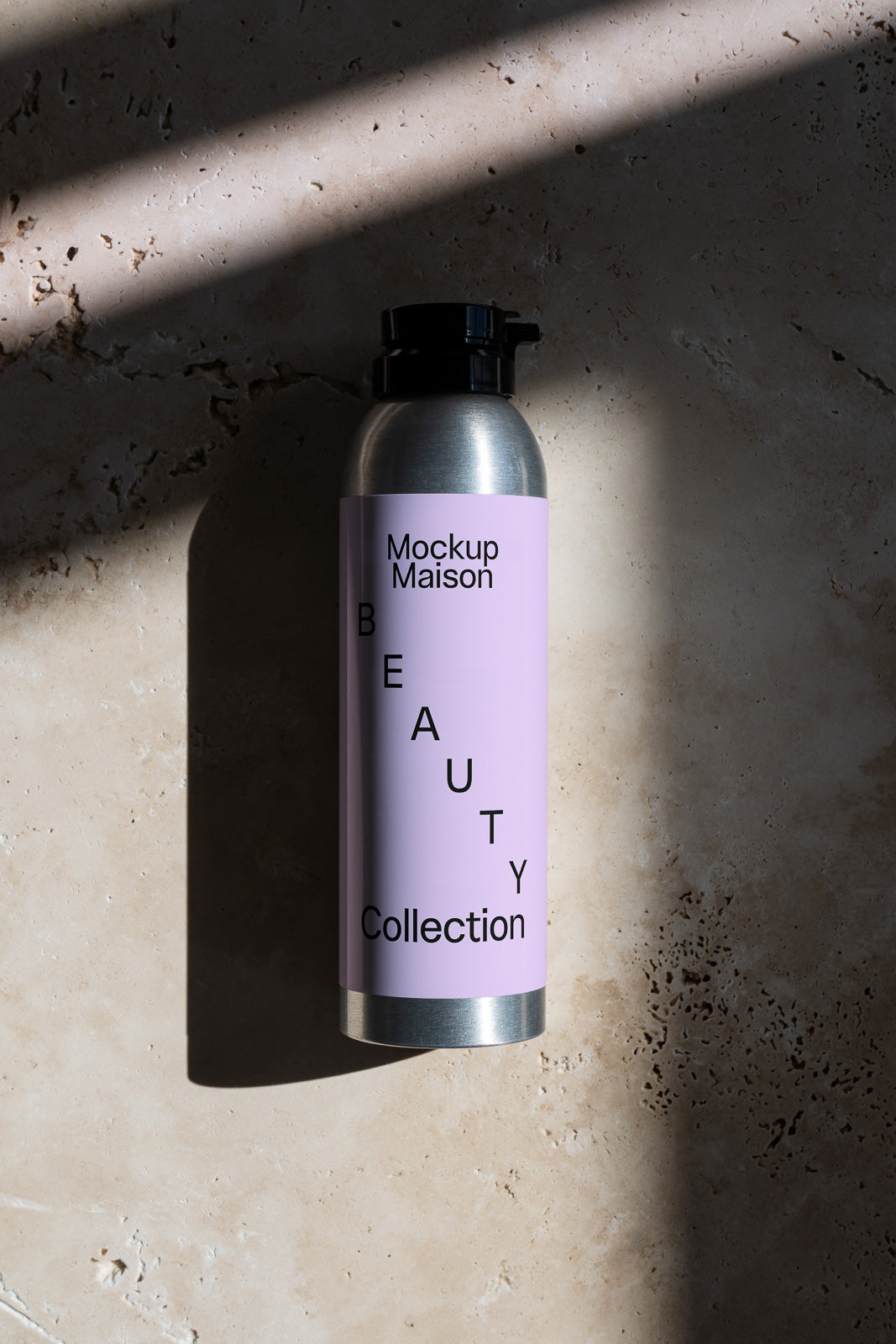 PSD mockup of a metallic bottle with a lavender label displaying "Mockup Maison Beauty Collection," set against a textured surface.