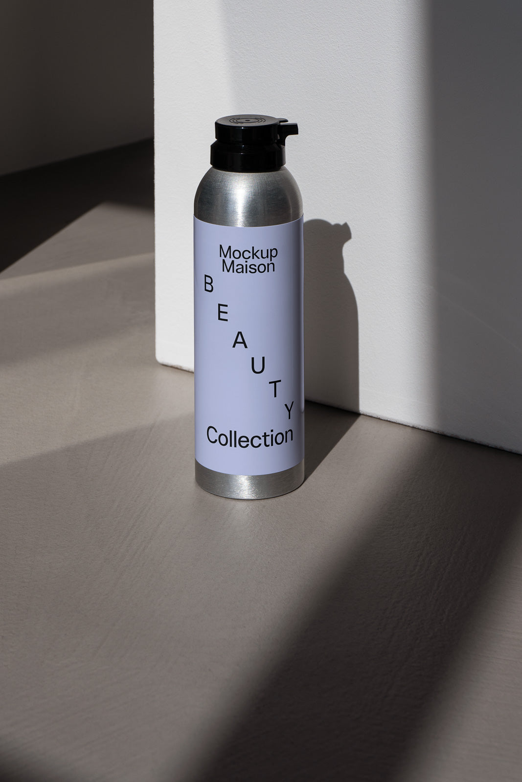 PSD mockup of a cylindrical silver bottle with a black cap and a lavender label featuring the word "Beauty" diagonally across the front.