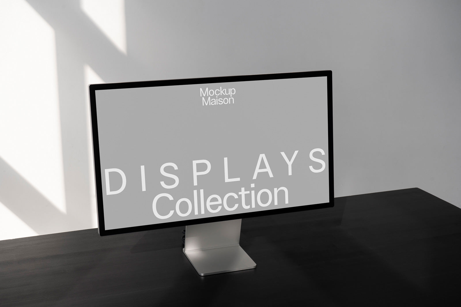PSD mockup of a sleek desktop monitor on a dark surface, displaying text "Displays Collection" against a minimalist gray background in a well-lit room.