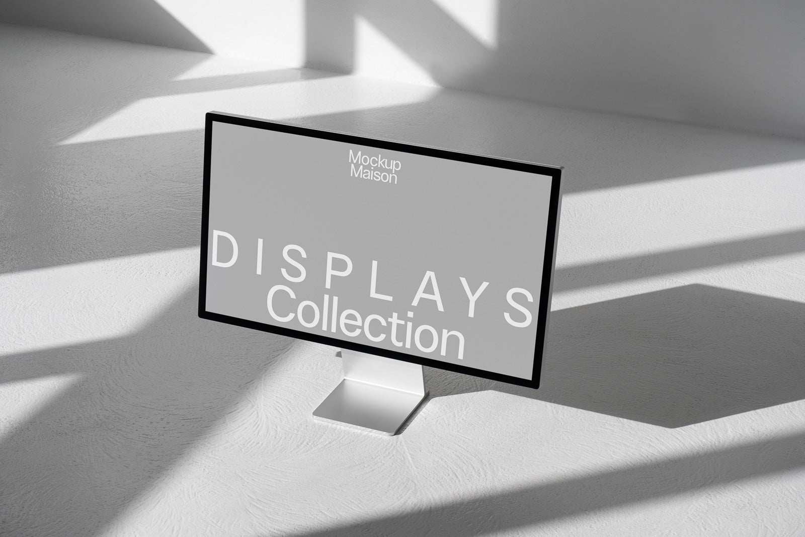 PSD mockup of a computer monitor displaying "Mockup Maison Displays Collection" in a minimalist setting with soft shadows and white surfaces.