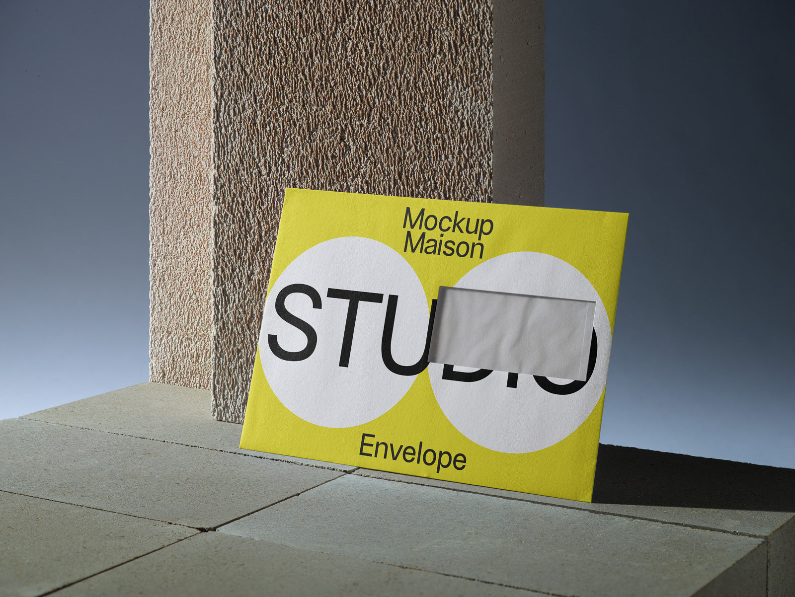 PSD mockup of a yellow envelope with bold black text partially visible through a rectangular window, leaning against a textured stone surface.