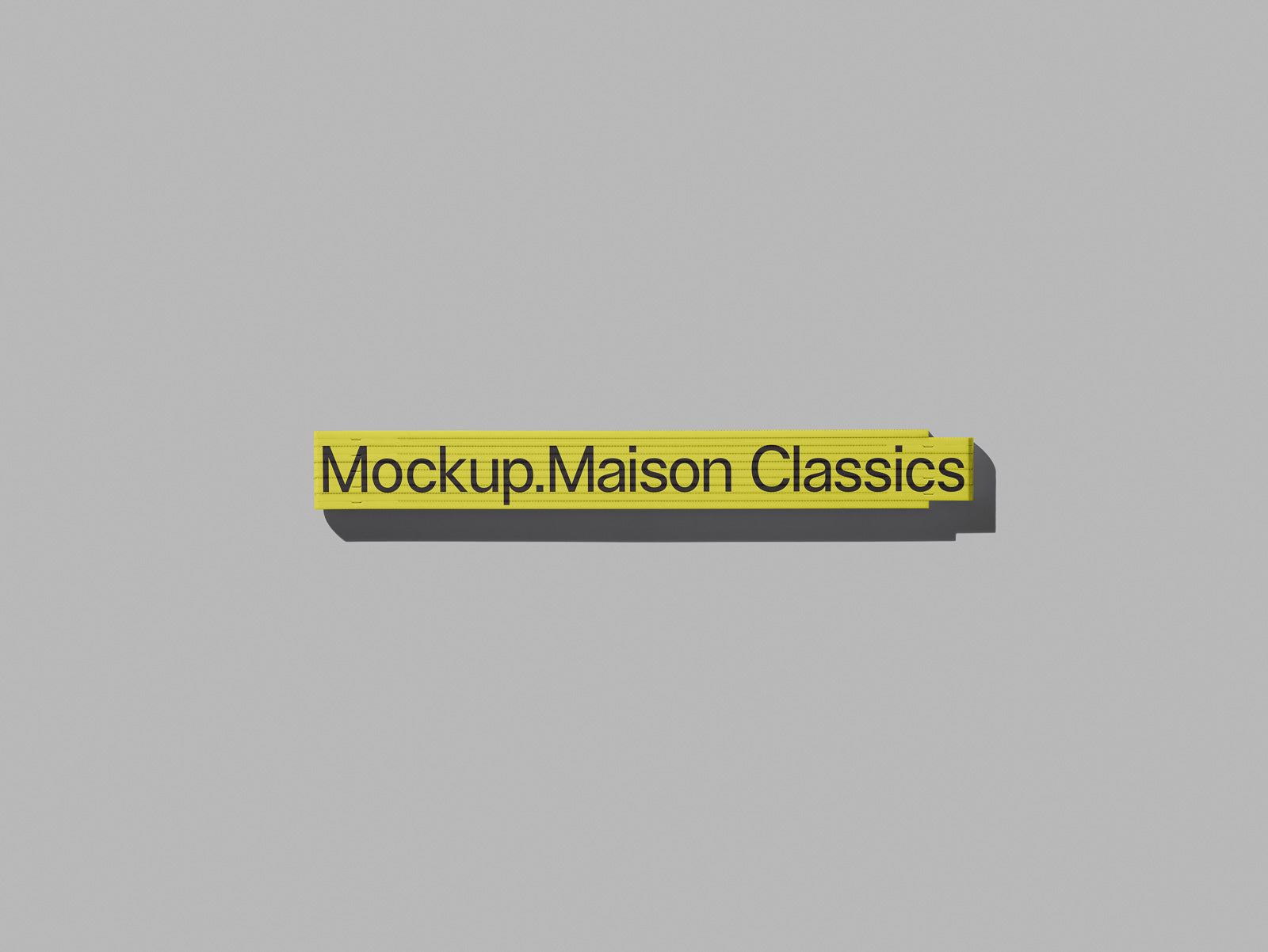 PSD mockup of yellow tape with black text "Mockup.Maison Classics" against a gray background, creating a minimalist and modern design aesthetic.