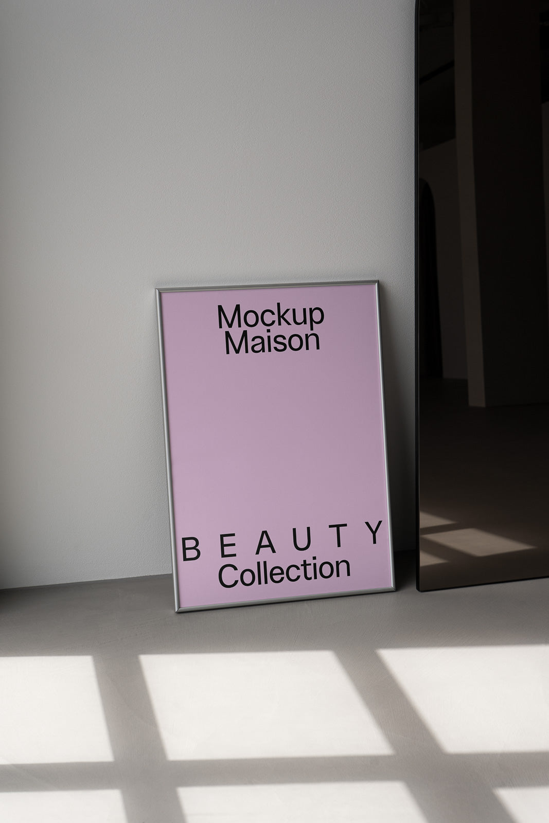 PSD mockup of a framed poster leaning against a wall, titled "Mockup Maison Beauty Collection" on a soft pink background, with shadows on the floor.