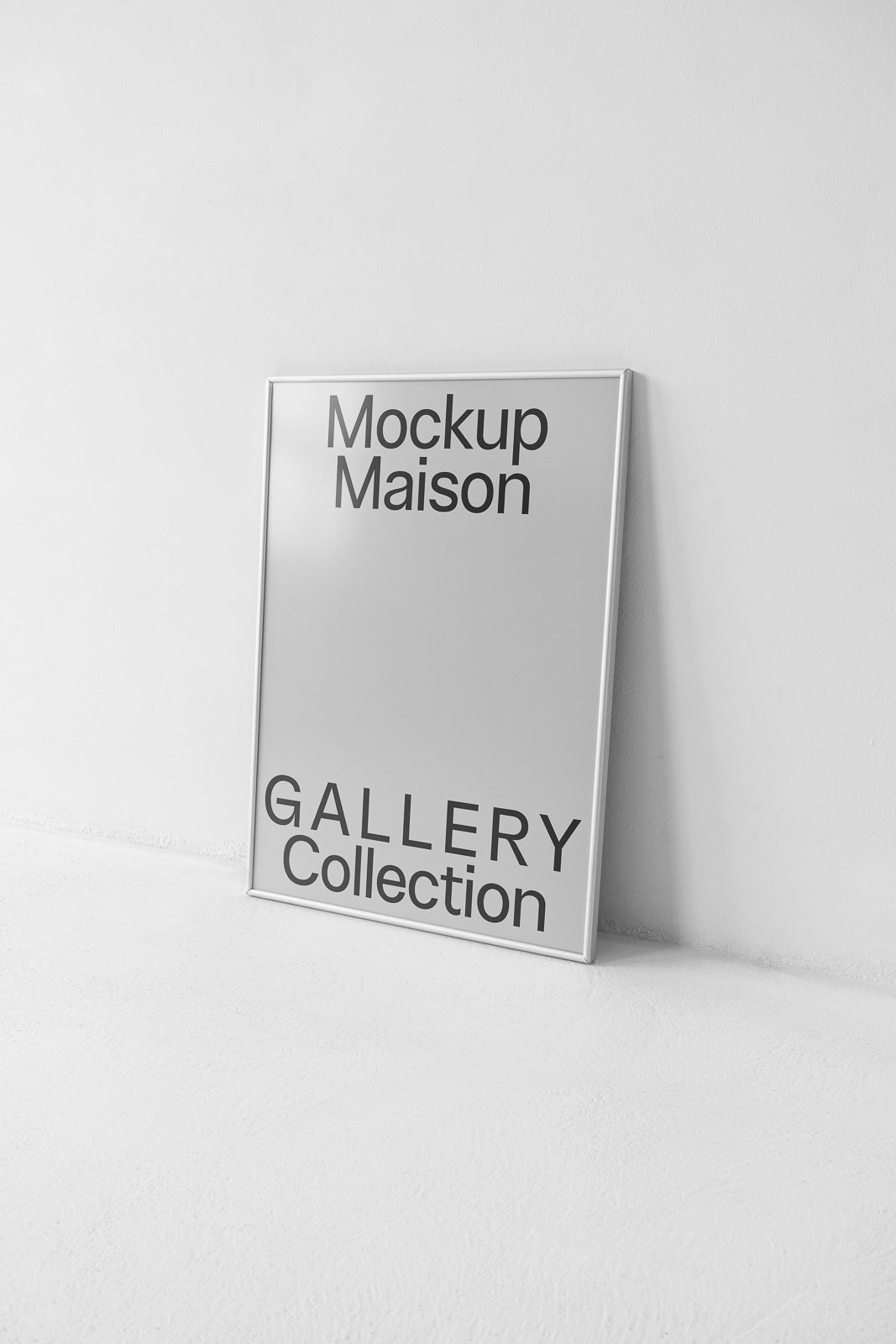 PSD mockup of a portrait frame leaning against a white wall displaying "Mockup Maison" and "Gallery Collection" text on a smooth surface.