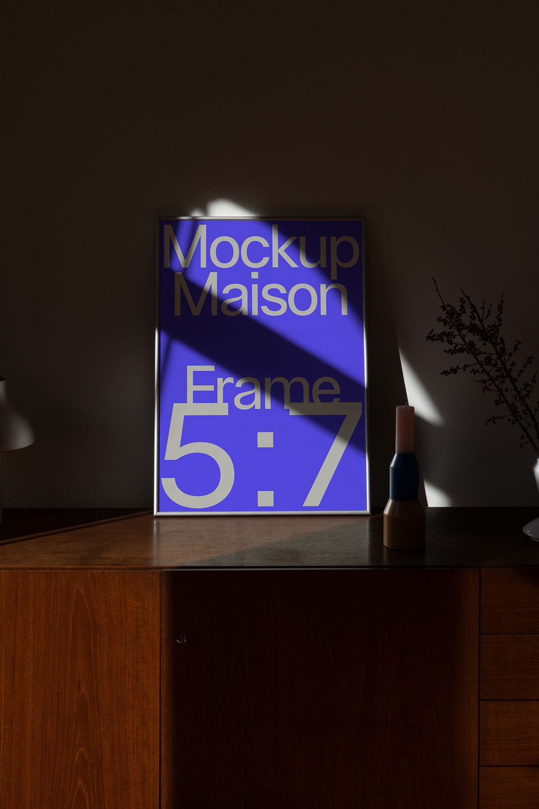 PSD mockup of a 5:7 frame on a wooden cabinet with soft shadows, featuring a blue poster with bold typography.