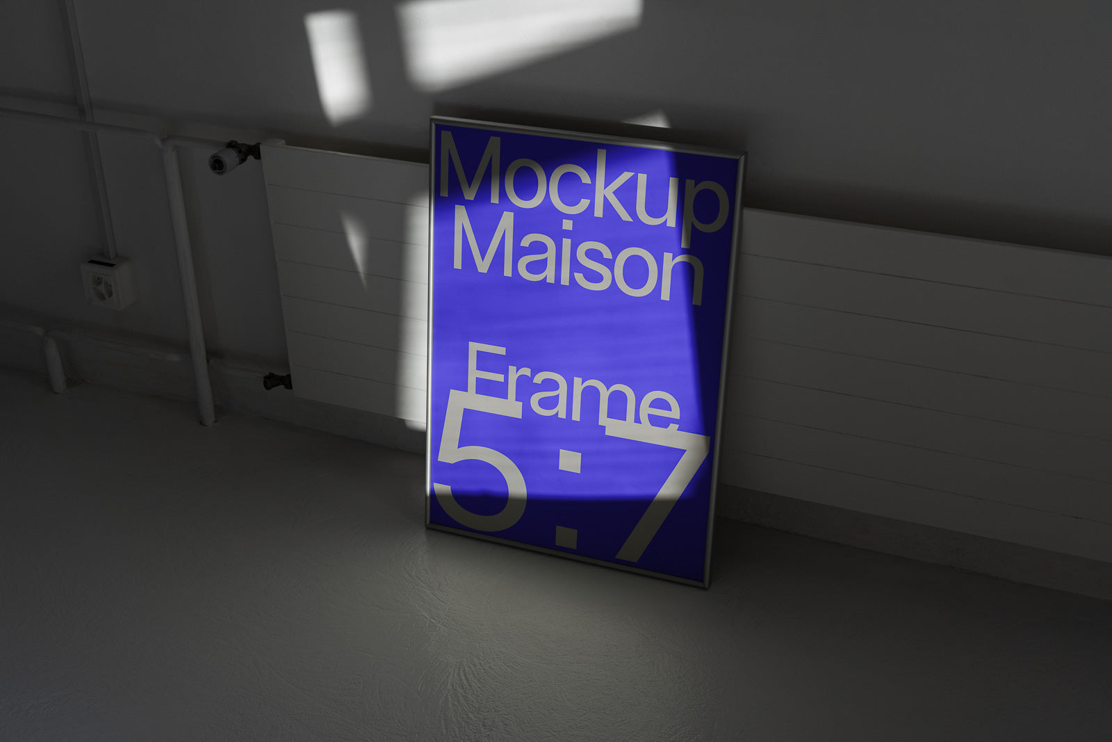 PSD mockup of a blue poster leaning against a white radiator, displaying the text "Mockup Maison Frame 5:7" with sunlight casting shadows.