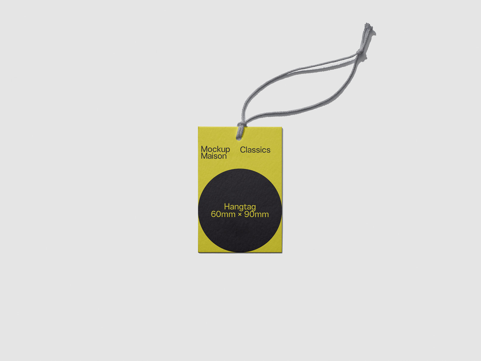 PSD mockup of a yellow hangtag with a black circle and text "Hangtag 60mm x 90mm", attached with a grey string, labeled "Mockup Maison Classics".