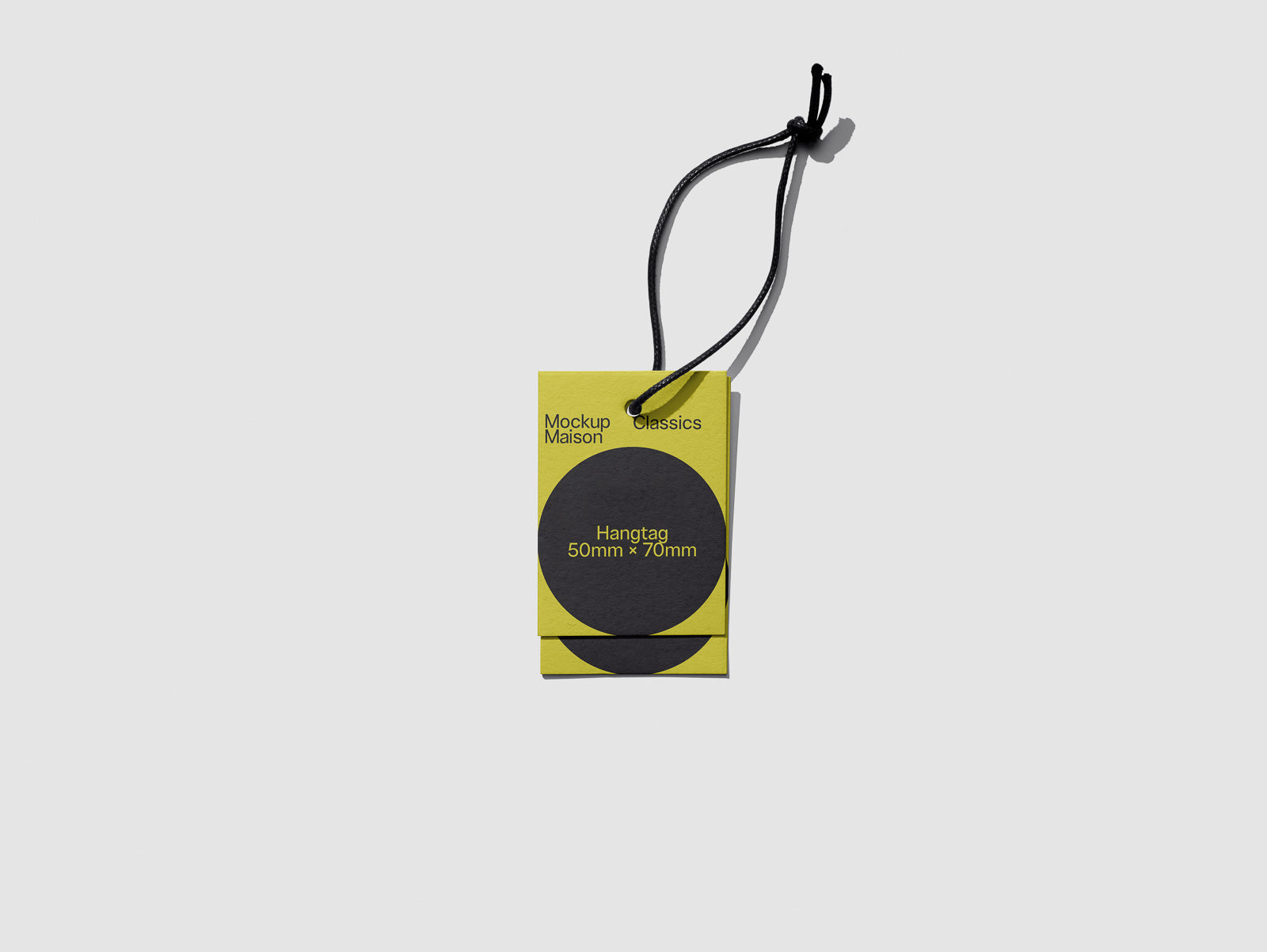 PSD mockup of a yellow hangtag with a black circular design, labeled "Mockup Maison Classics" and measuring 50mm x 70mm, attached by a black string.