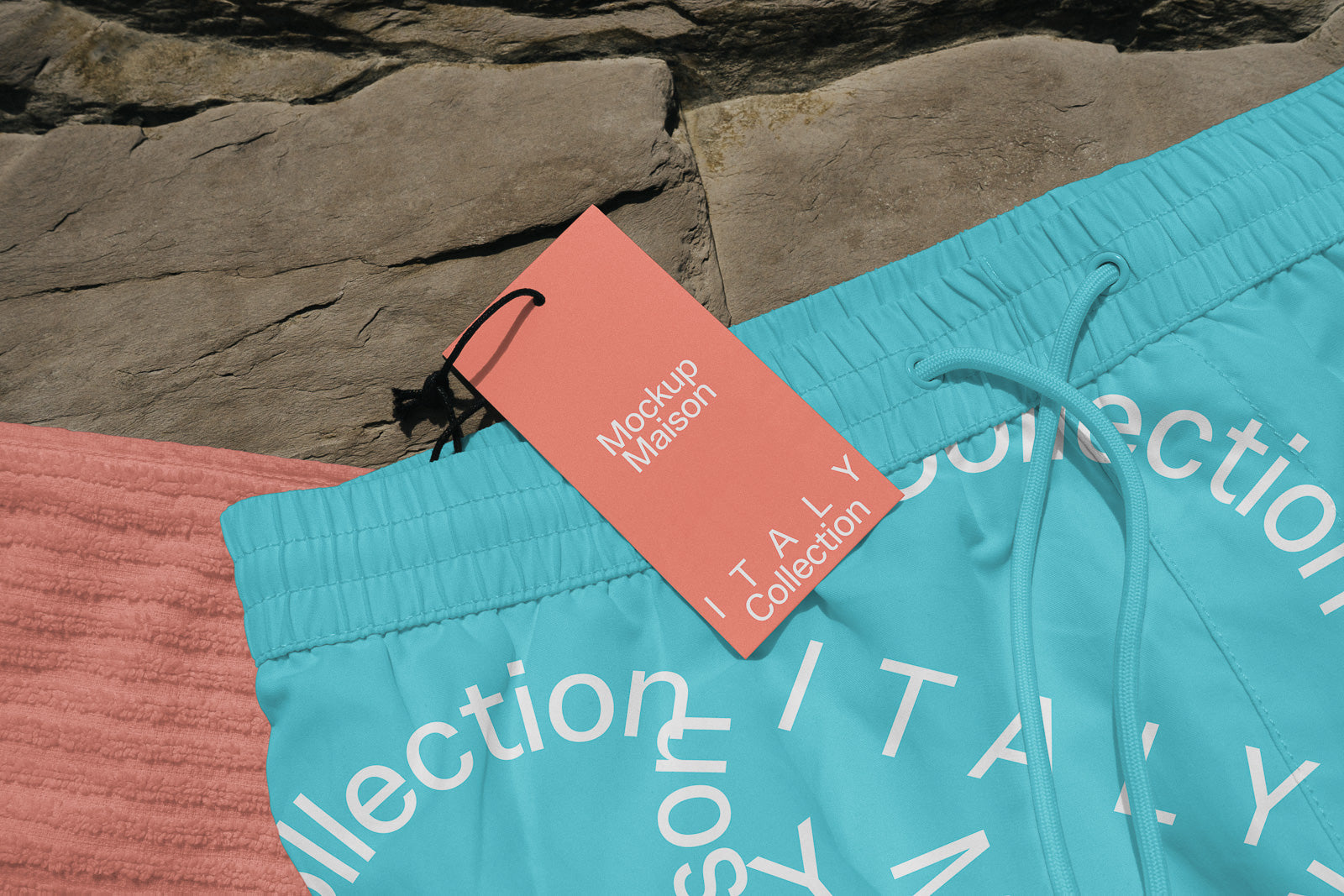 PSD mockup of blue shorts with "ITALY Collection" tag and drawstring, displayed on a textured stone background.