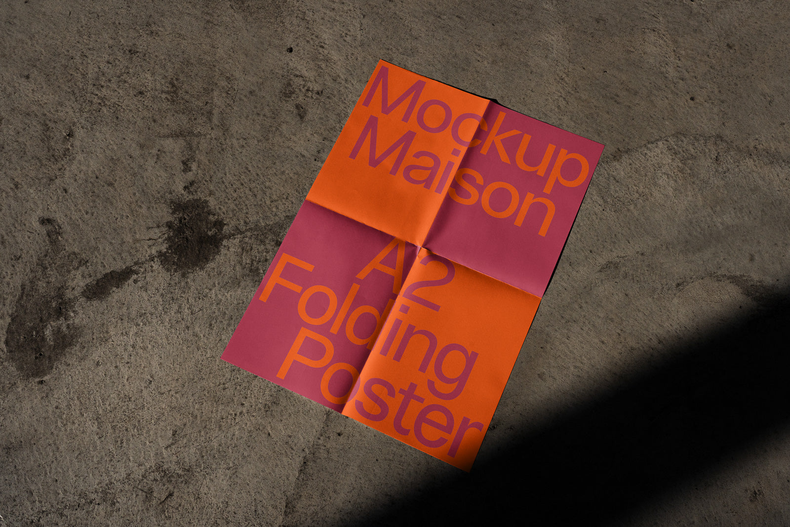 PSD mockup of a vibrant A2 folding poster with large text in bold colors on a textured concrete surface.