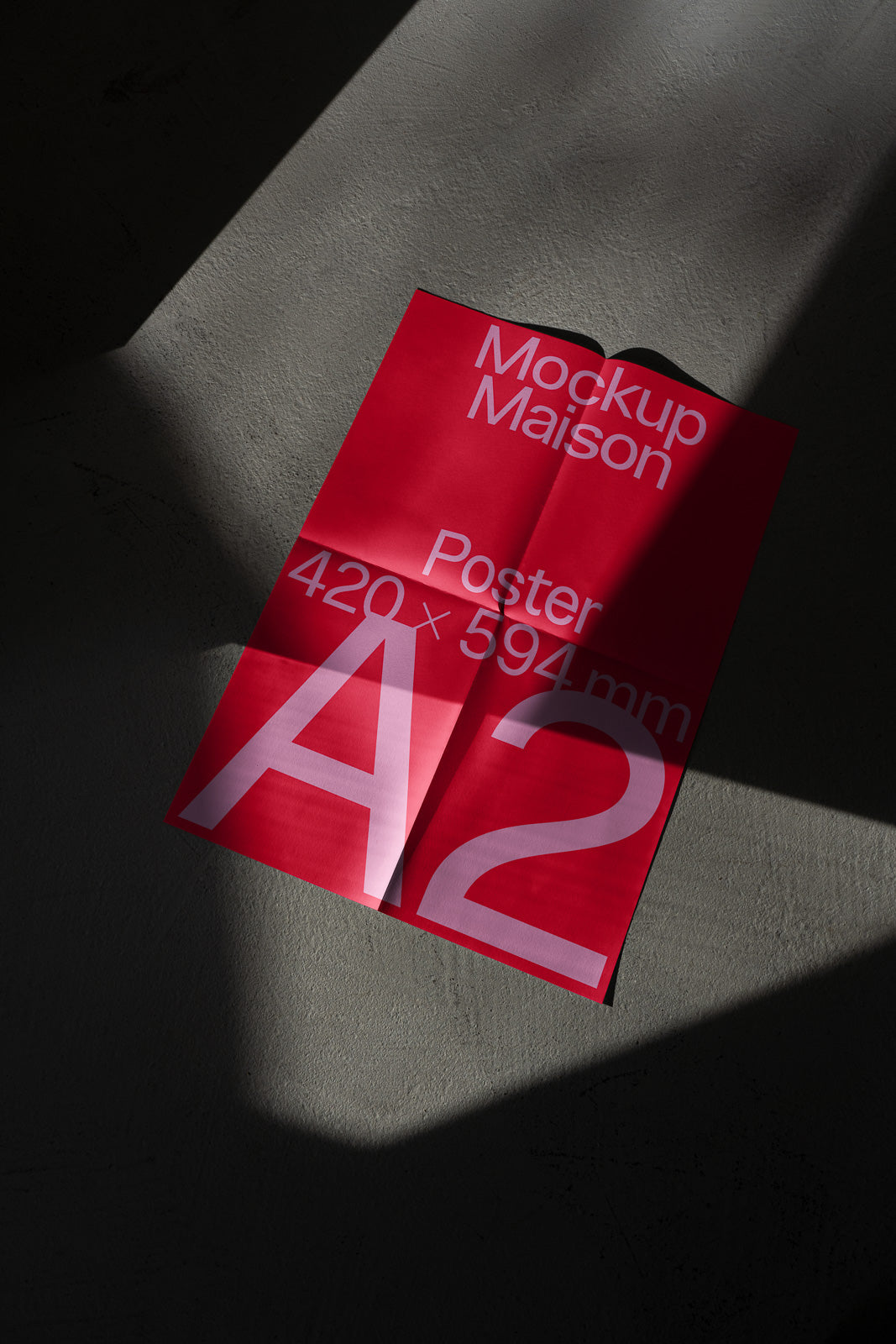 PSD mockup of an A2 poster with bold white text on a red background, showcasing dimensions 420 x 594 mm, placed on a textured surface with shadow play.