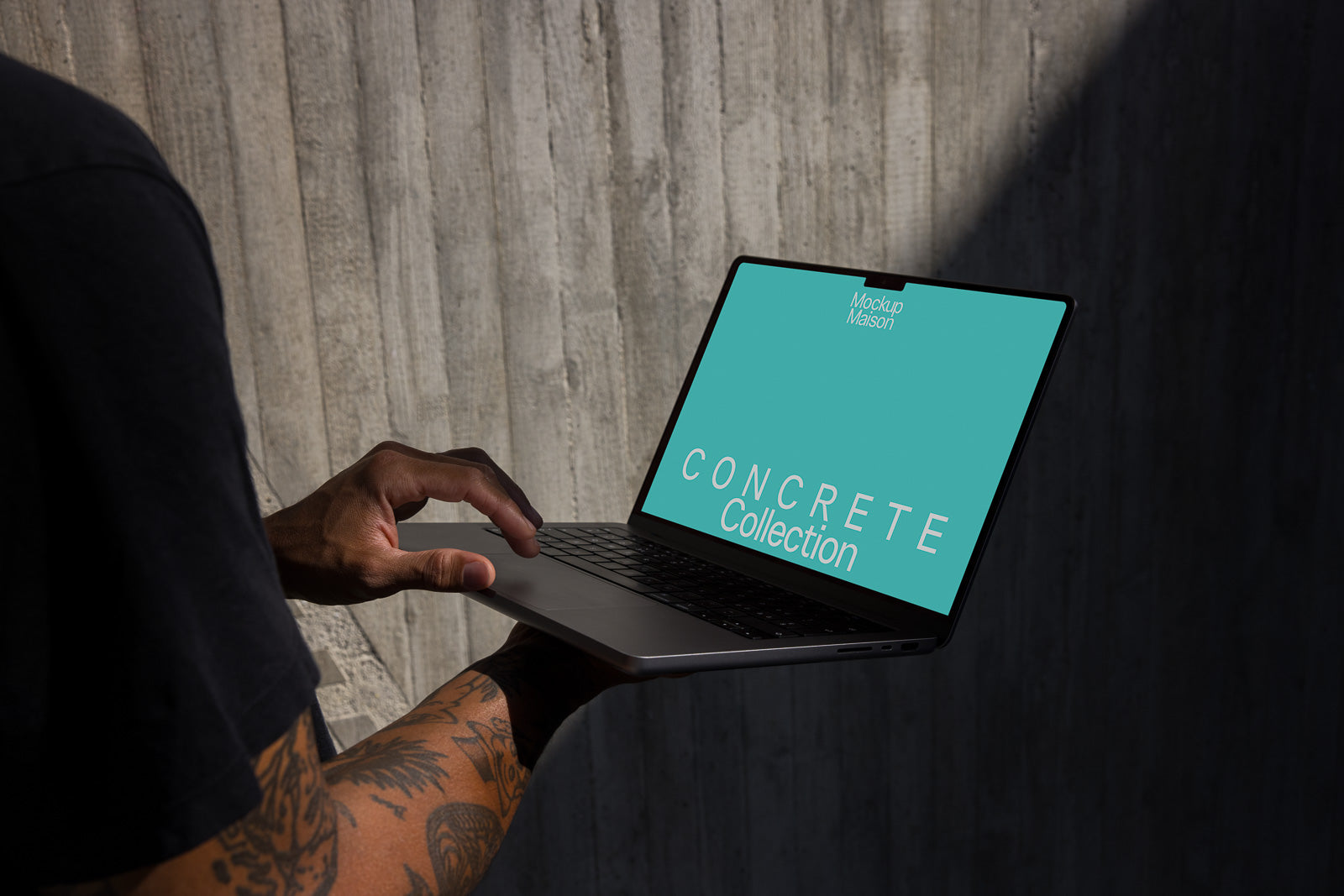 PSD mockup of a person holding a laptop displaying a screen with the text "Concrete Collection" and "Mockup Maison" against a blue background.