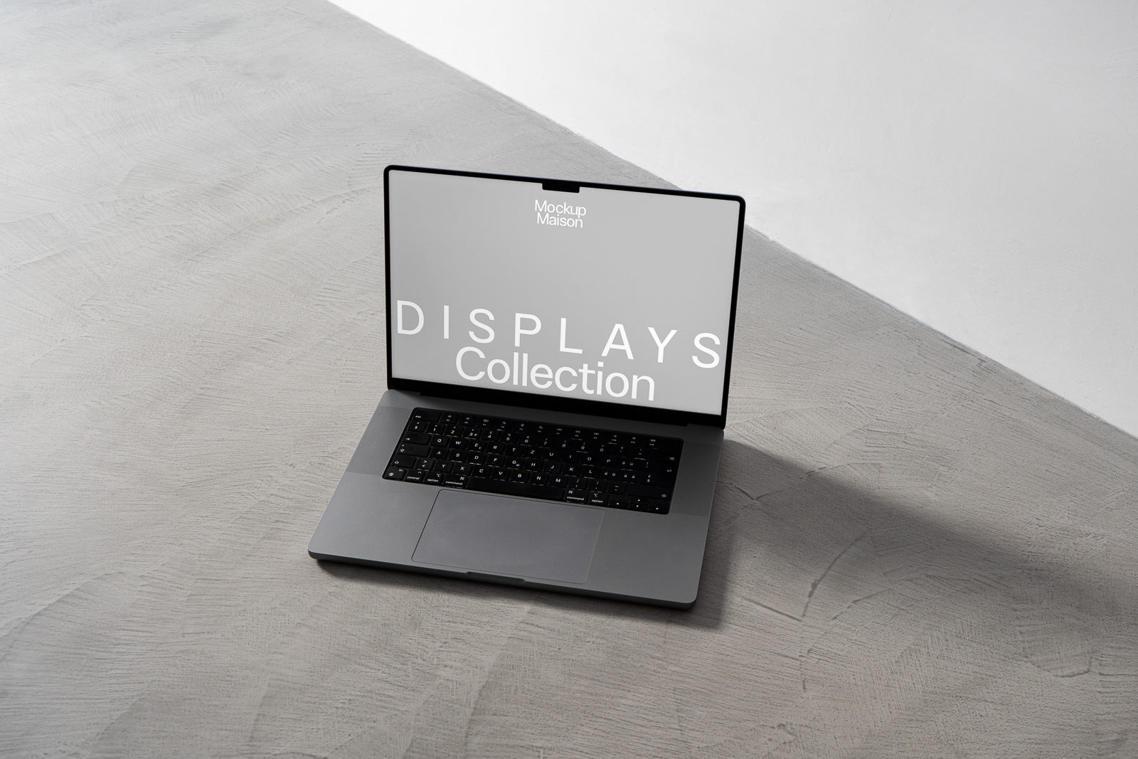 PSD mockup of an open laptop on a gray surface displaying "DISPLAYS Collection" on its screen, with minimalist design and shadow.