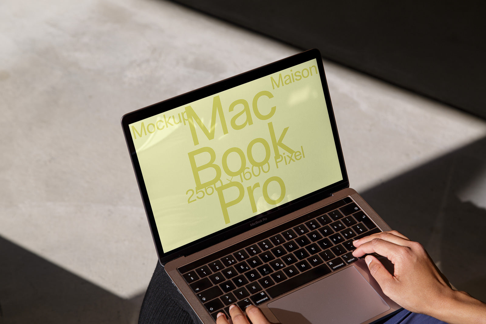 PSD mockup of an open MacBook Pro on a person's lap, displaying text in large yellow font against a beige background.