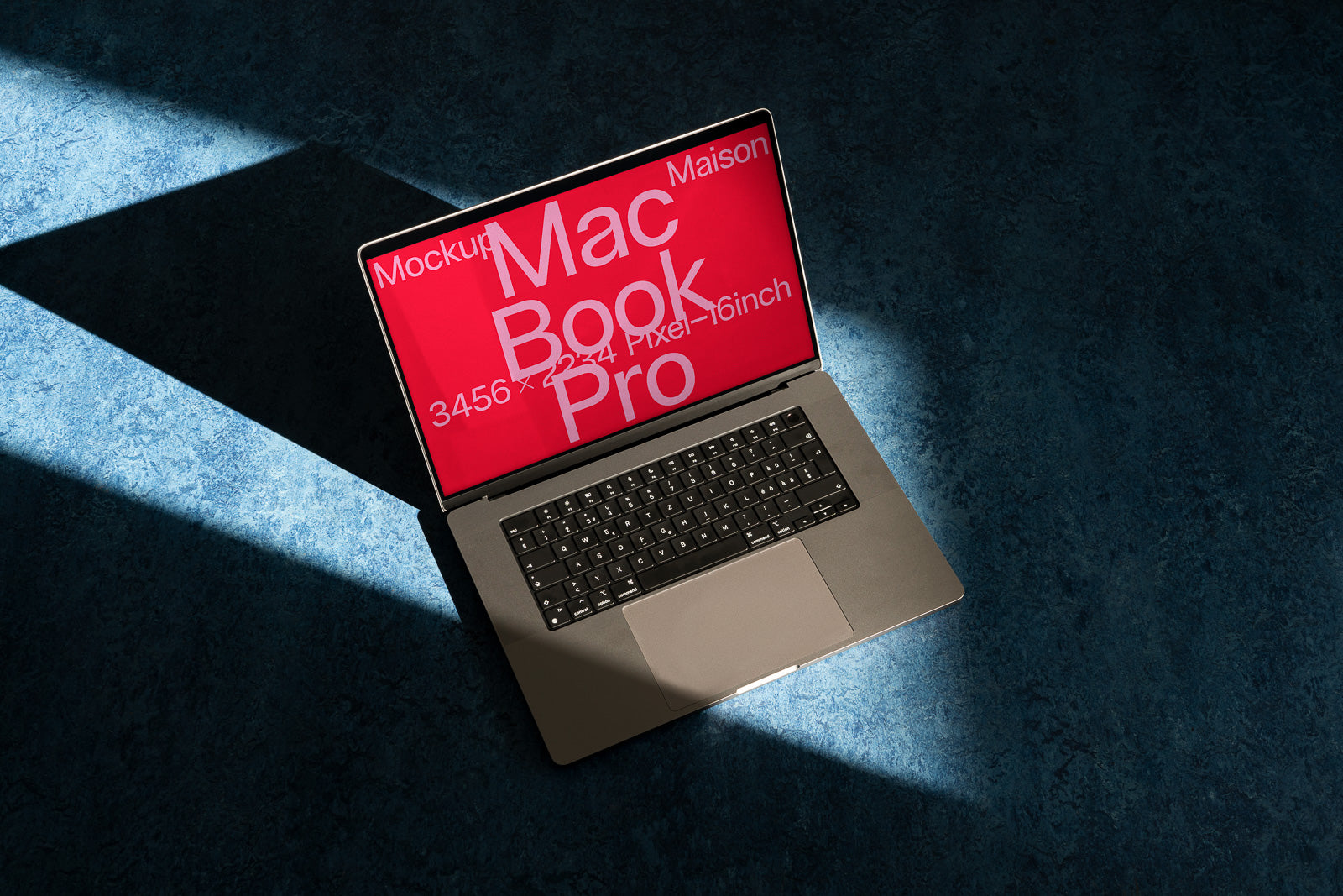 PSD mockup of a laptop with a red screen displaying text, placed on a blue textured surface in a dramatic light, highlighting the keyboard and screen.