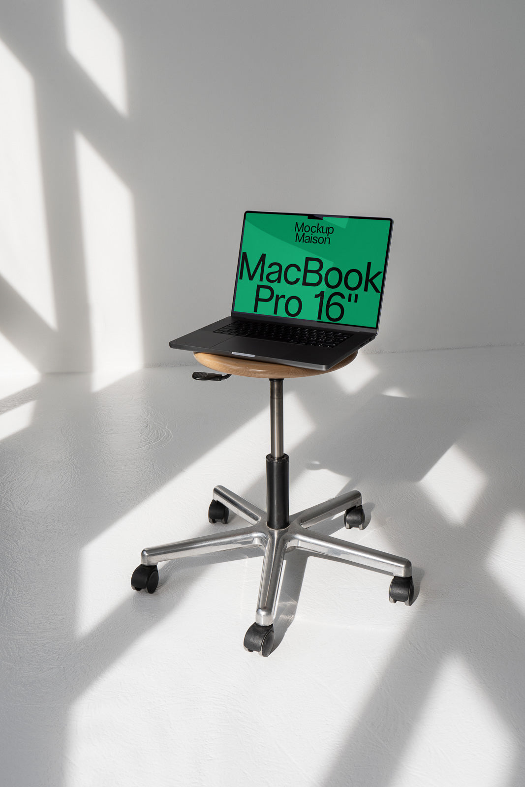 PSD mockup of a MacBook Pro 16" on a wheeled stand in a sunlit room with shadows on the floor.