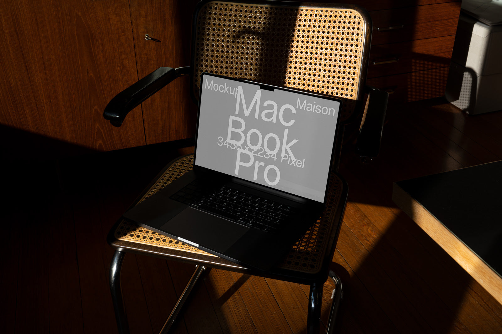 PSD mockup of an open laptop on a woven wooden chair in a sunlit room, displaying text about its screen resolution and model details.