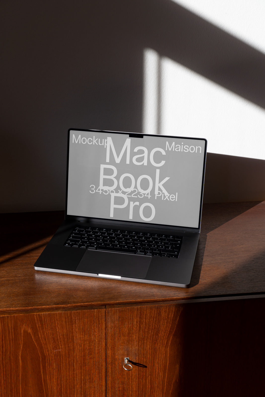PSD mockup of a MacBook Pro on a wooden desk with sunlight filtering through blinds, displaying text featuring mockup resolution details.