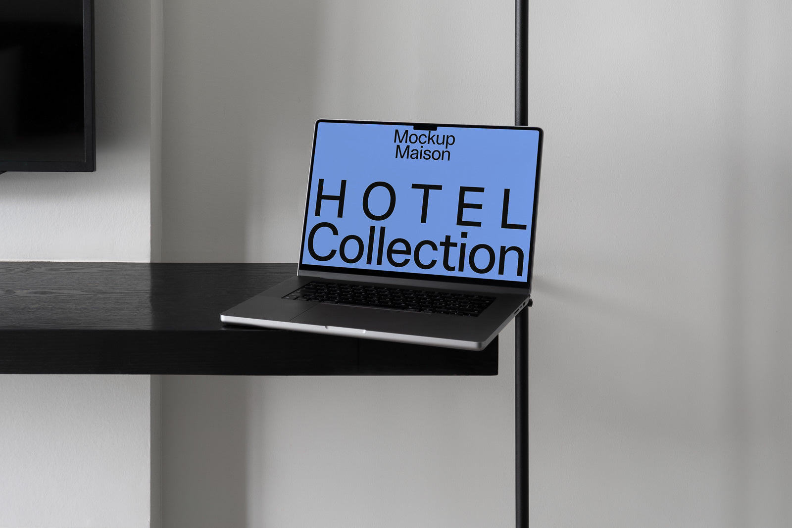 PSD mockup of a laptop resting on a modern black shelf, displaying "Mockup Maison HOTEL Collection" on its screen in bold text.