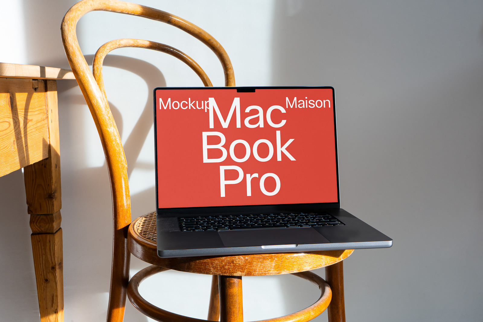 PSD mockup of a laptop with a red screen displaying "MacBook Pro" text, placed on a wooden chair, sunlight creating shadows.