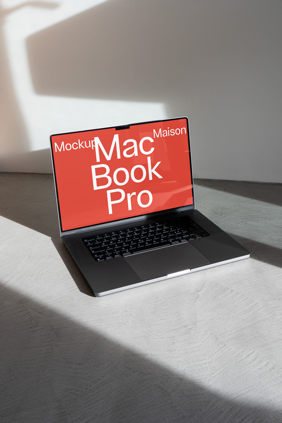 PSD mockup of a MacBook Pro with a red screen displaying the words "Mockup Maison" in bold letters, set against a minimalistic background.