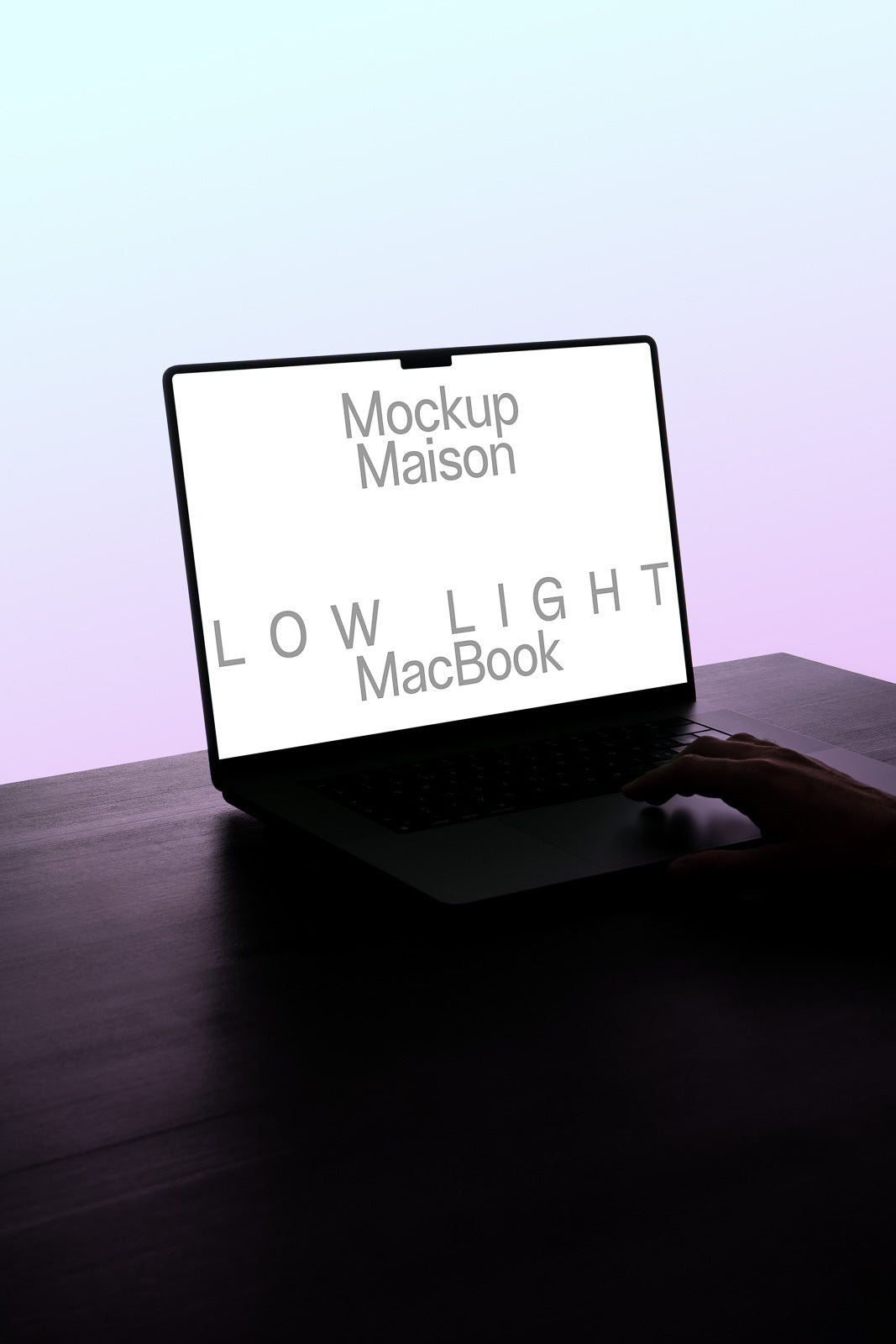 PSD mockup of a MacBook in low light with a hand touching the keyboard, displaying "Mockup Maison" on the screen.