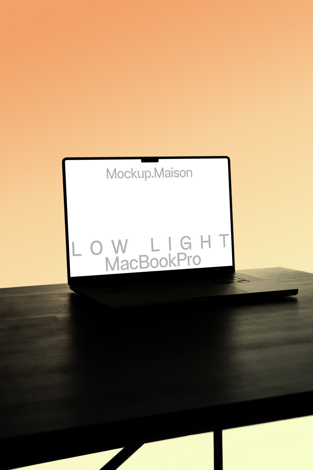 PSD mockup of a MacBook Pro on a dark table against a gradient orange background, displaying "Mockup.Maison" on the screen.