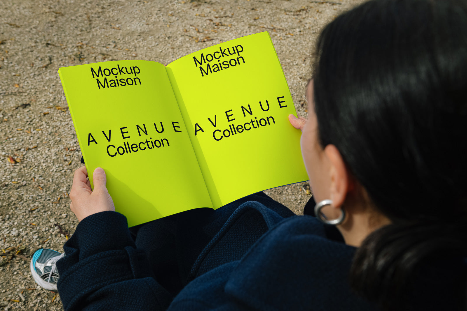PSD mockup of a person holding an open magazine featuring the "Avenue Collection" text on bright green pages, with "Mockup Maison" written on top.