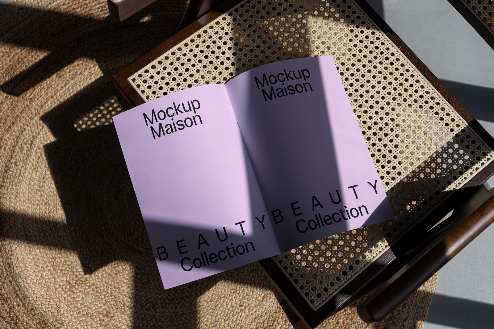 PSD mockup of an open lavender booklet titled "Mockup Maison" with "Beauty Collection" text, placed on a woven chair with sunlight and shadow.