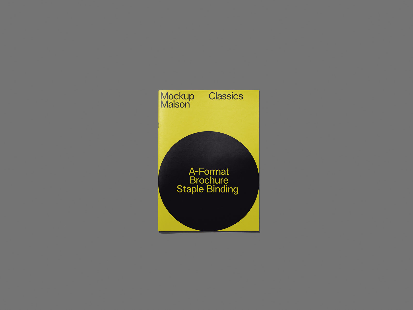 PSD mockup of a yellow brochure with a black circle on the cover displaying "A-Format Brochure Staple Binding" on a gray background.