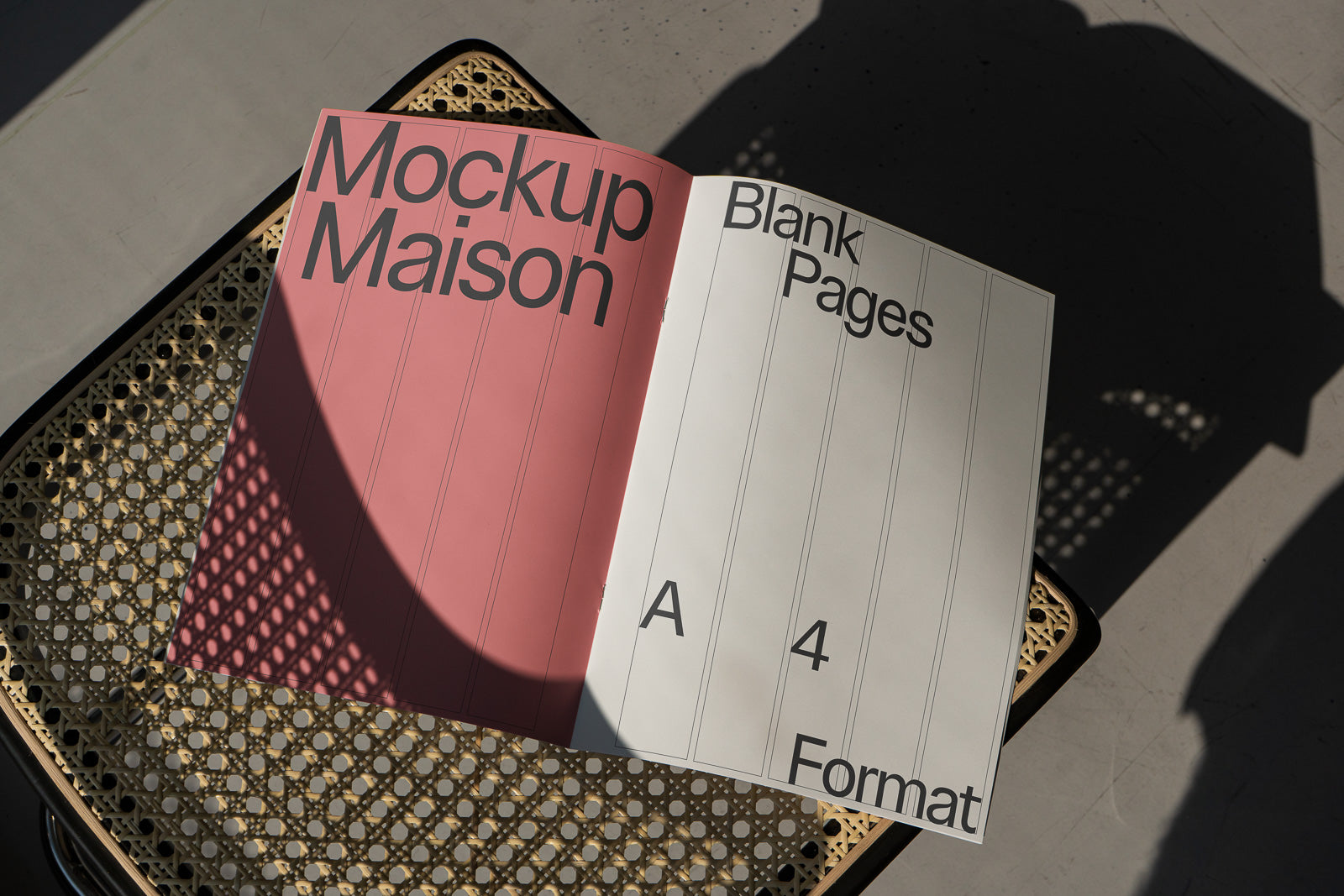 PSD mockup of an open A4-format booklet titled "Mockup Maison" with blank pages, placed on a woven chair with sunlight and shadow play.