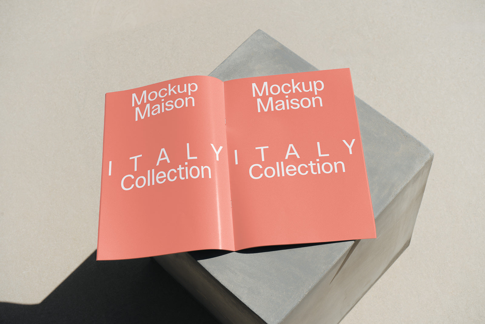 PSD mockup of a booklet labeled "Mockup Maison ITALY Collection" resting on a concrete block under sunlight, showcasing its design and typography.