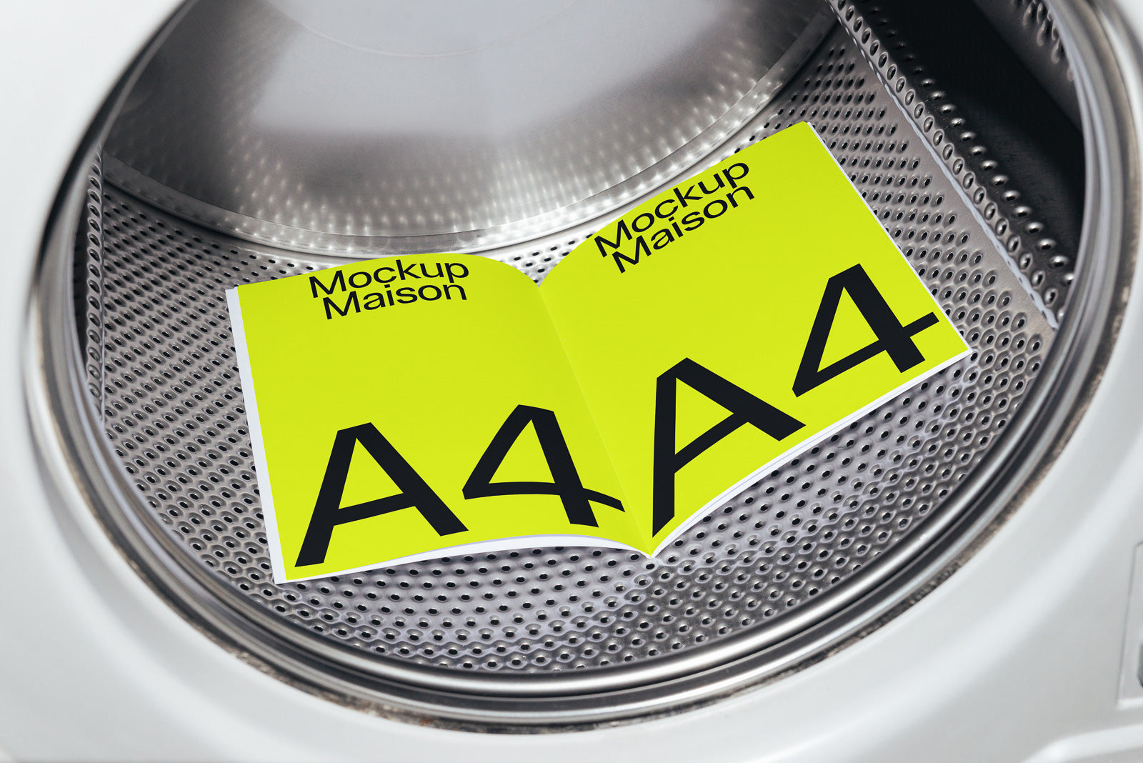 PSD mockup of an A4 booklet displayed inside a washing machine drum, showcasing its vibrant yellow cover with bold black text and design elements.