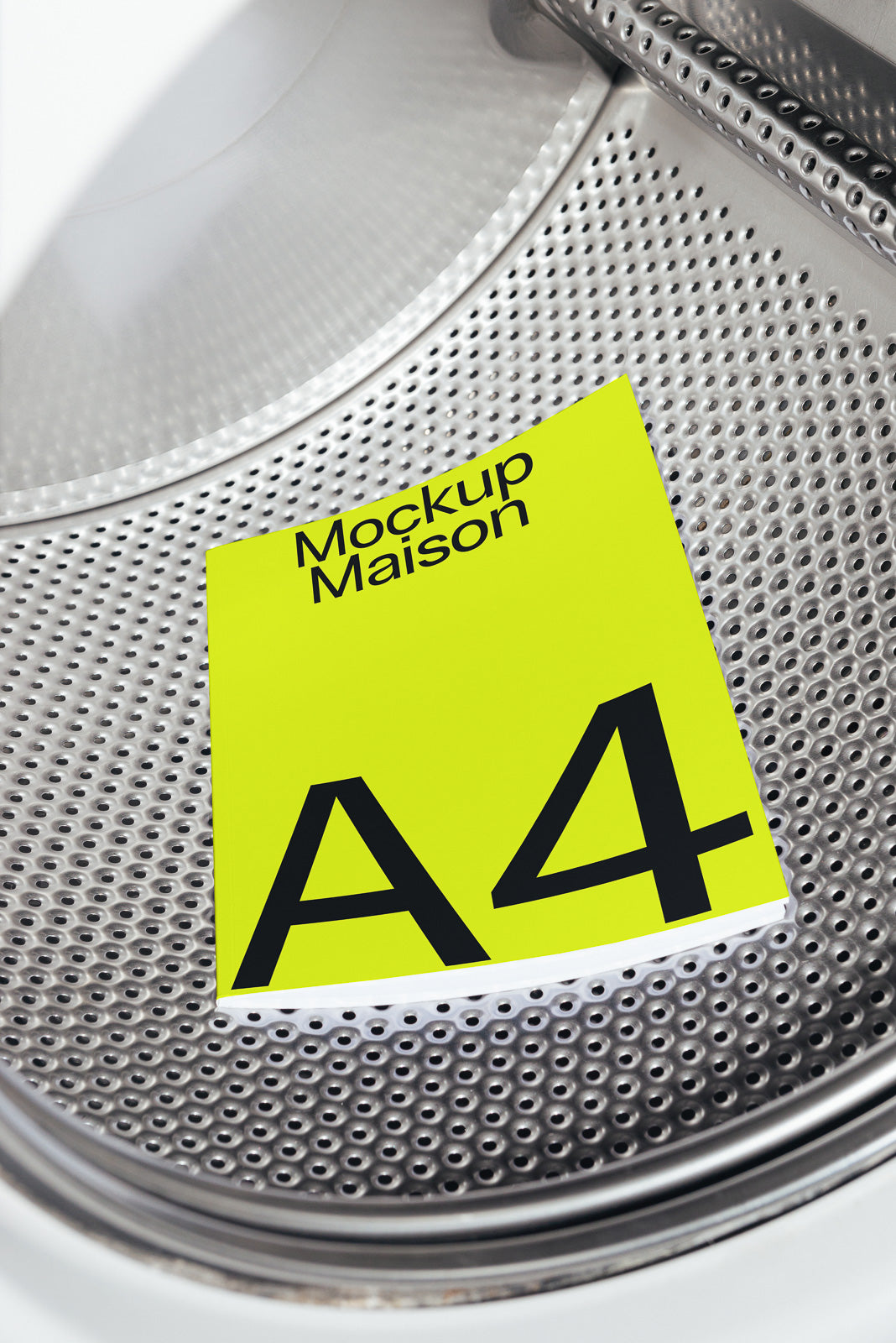 PSD mockup of an A4 booklet with a bright yellow cover titled "Mockup Maison," placed inside a metallic drum with perforated texture.