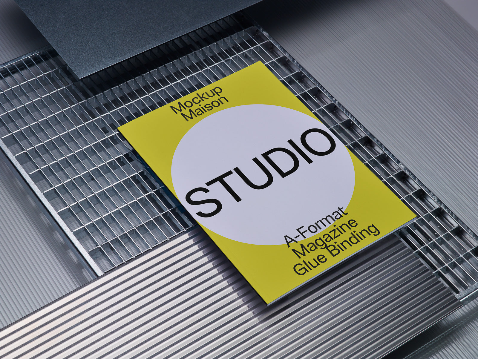 PSD mockup of a magazine cover titled "STUDIO" placed on a metallic grid background, featuring a yellow and white design with text about A-Format and glue binding.