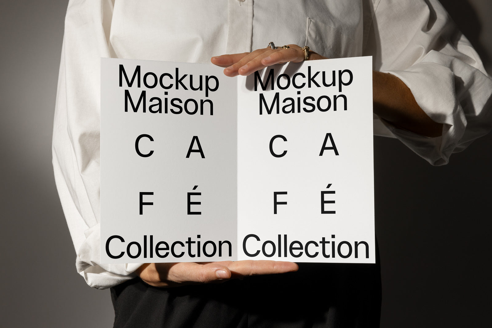 PSD mockup of a bifold brochure with "Mockup Maison" and "CA FÉ Collection" text held by a person in a white shirt.