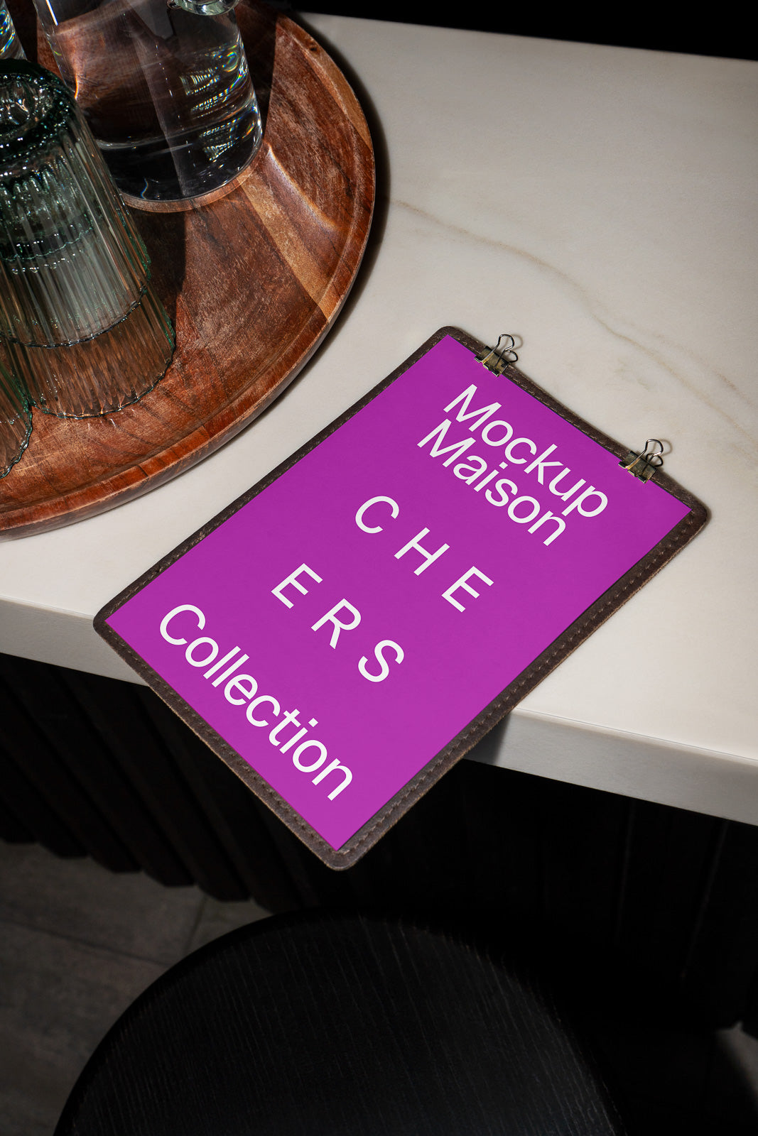 PSD mockup of a purple clipboard on a marble surface, displaying the text "Mockup Maison CHEERS Collection" near a wooden tray with glasses.