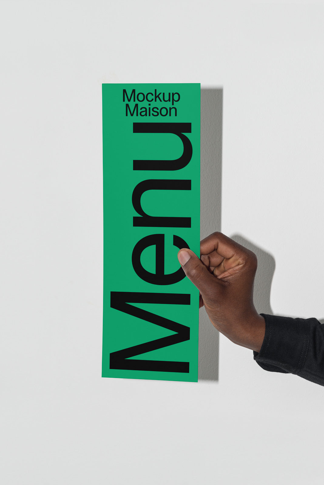 PSD mockup of a hand holding a green menu card labeled "Mockup Maison" against a light gray background.