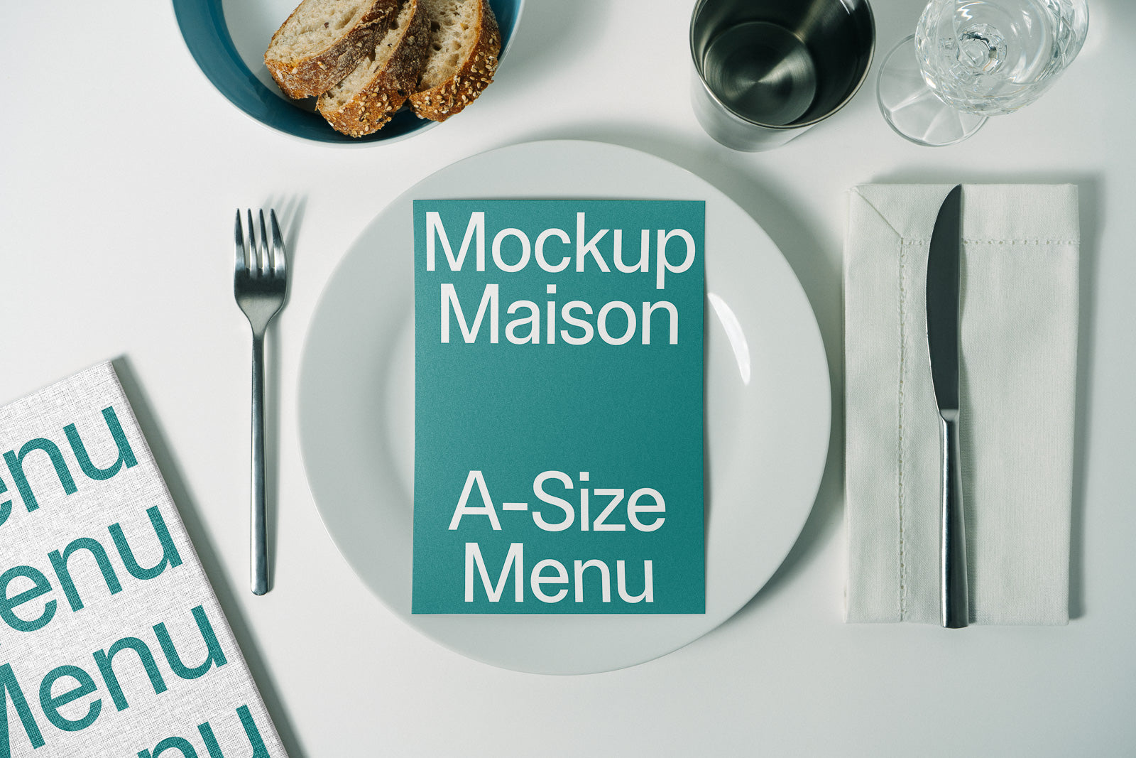 PSD mockup of an A-size menu on a white plate, accompanied by cutlery, a glass, a cup, and slices of bread, creating a dining setup.