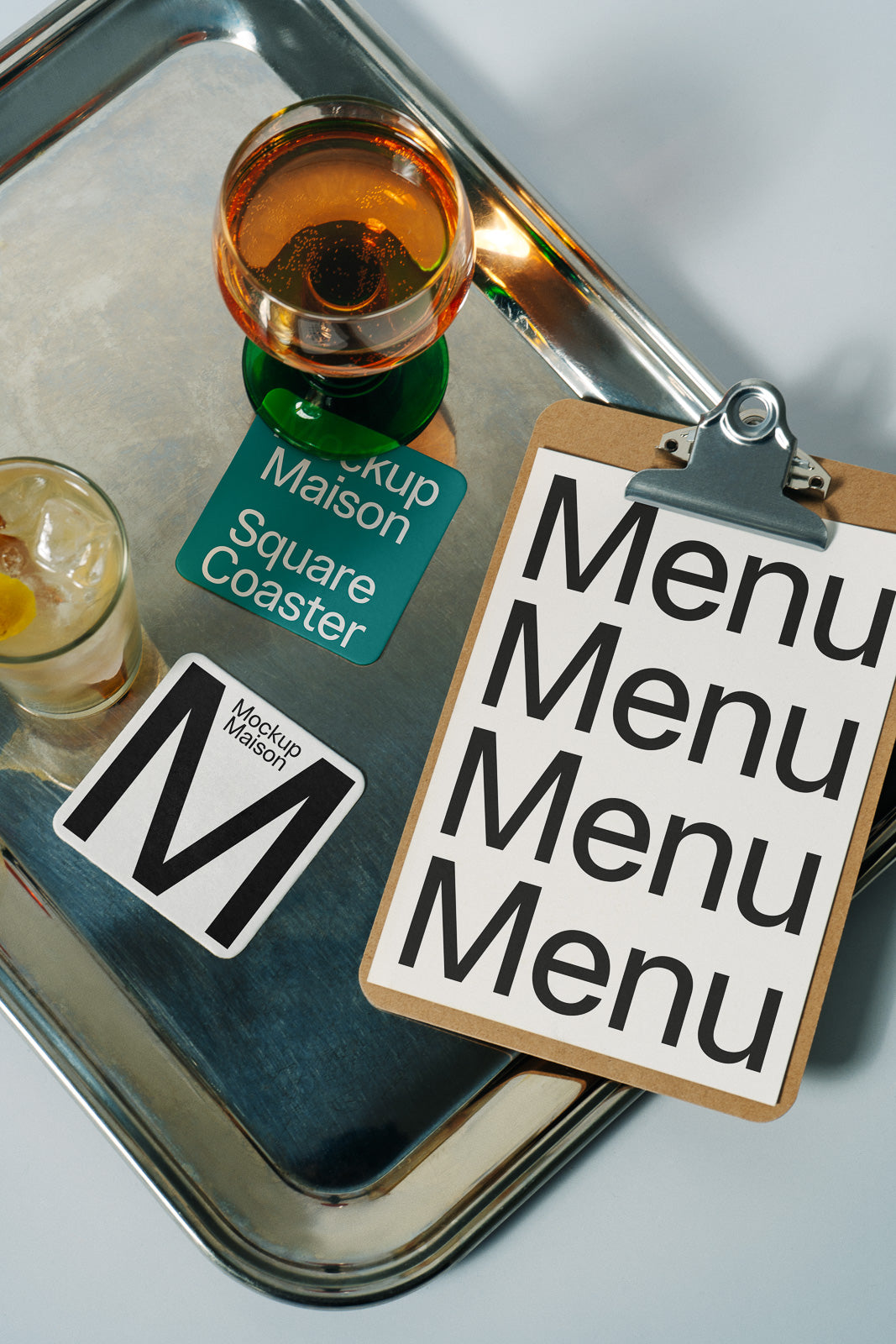 PSD mockup of a metallic tray with drinks and coasters, accompanied by a clipboard featuring a menu design, showcasing branding elements.