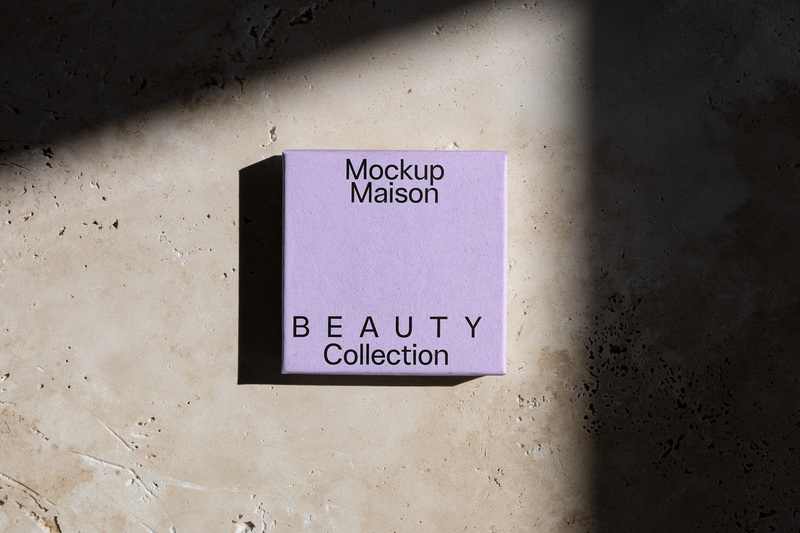 PSD mockup of a purple box labeled "Mockup Maison Beauty Collection" casts a shadow on a textured surface.