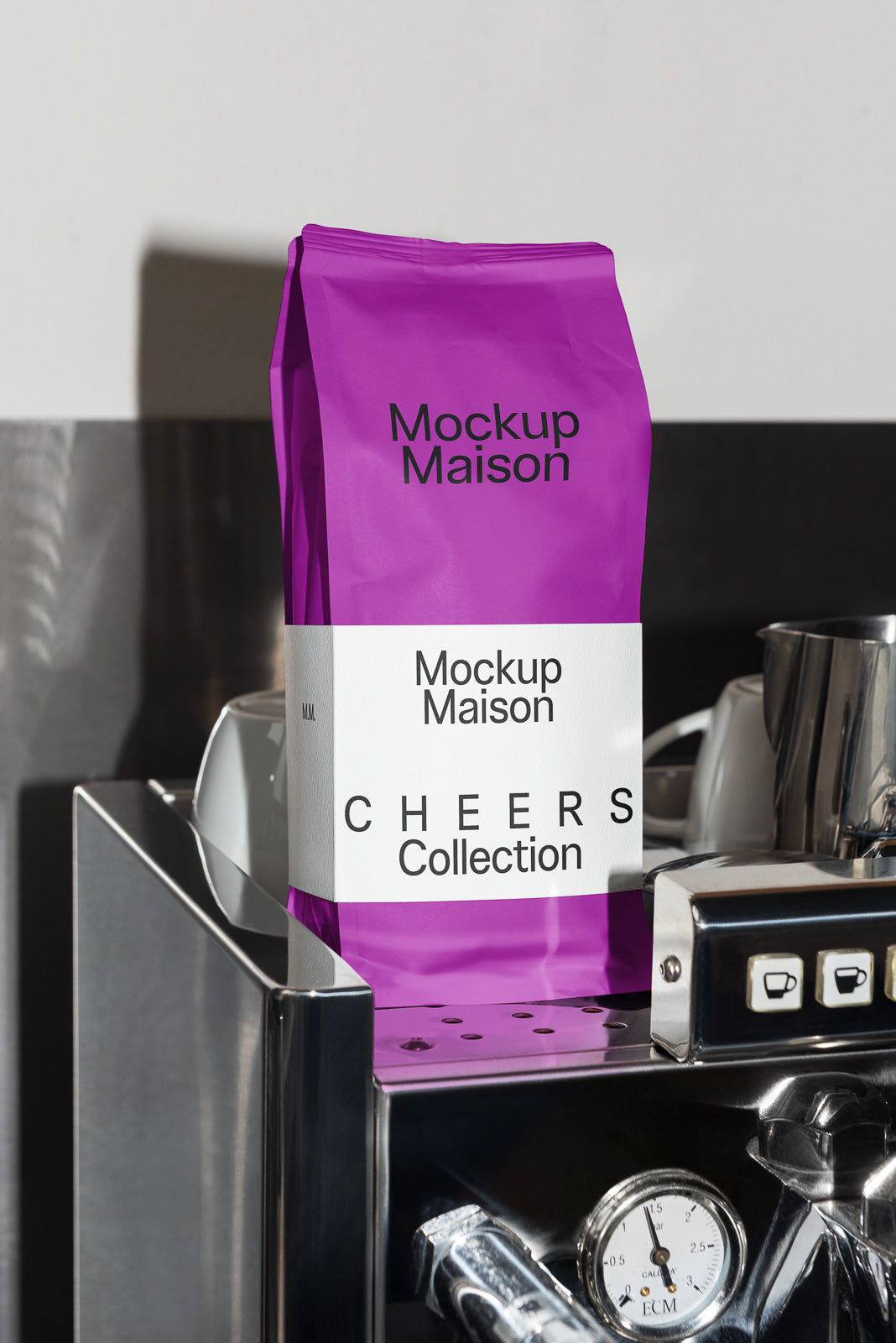 PSD mockup of a purple coffee bag labeled "Mockup Maison Cheers Collection" placed on an espresso machine, highlighting modern packaging design.