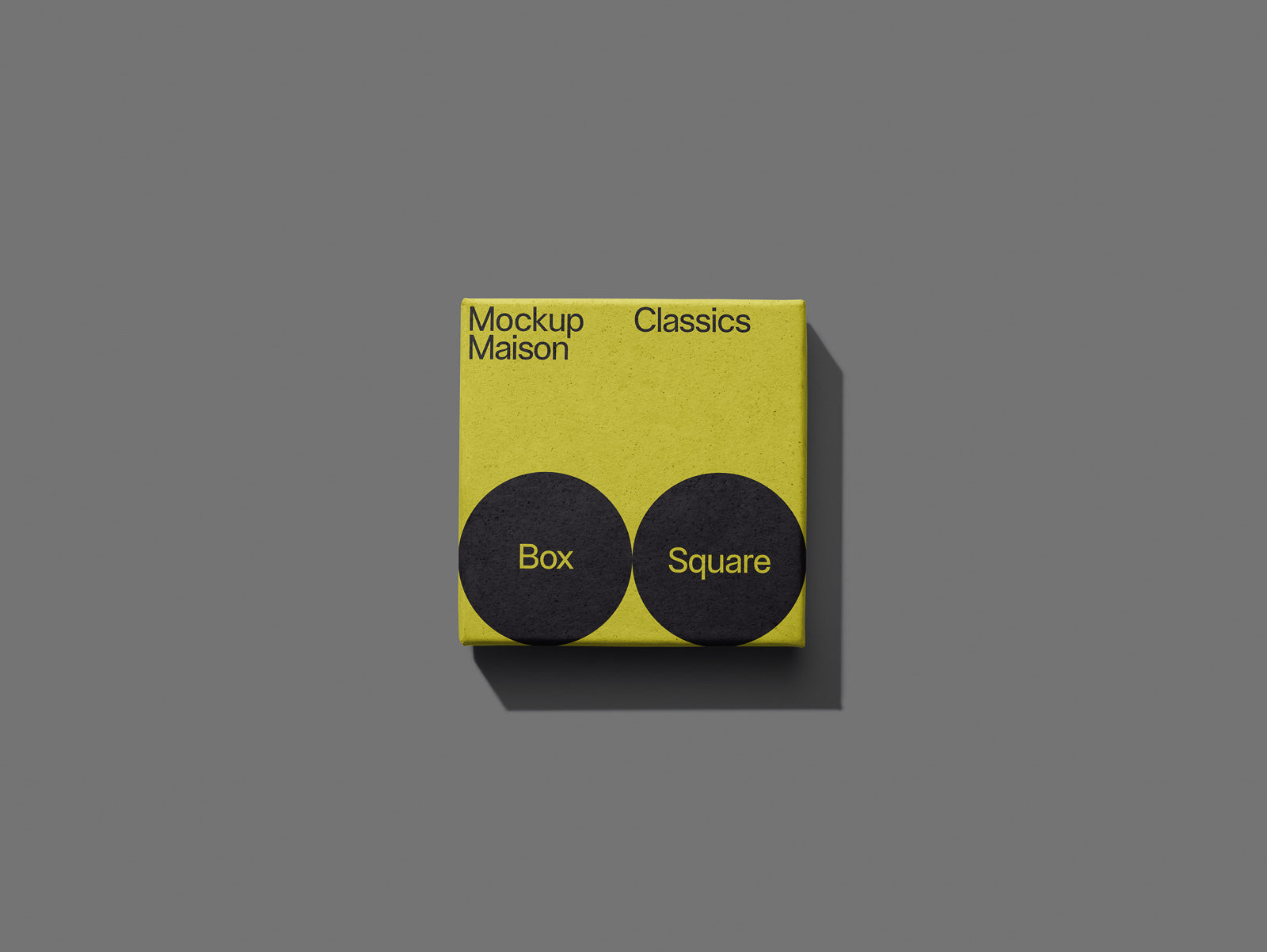 PSD mockup of a square yellow box labeled "Mockup Maison Classics" with two black circles containing the words "Box" and "Square" on a gray background.
