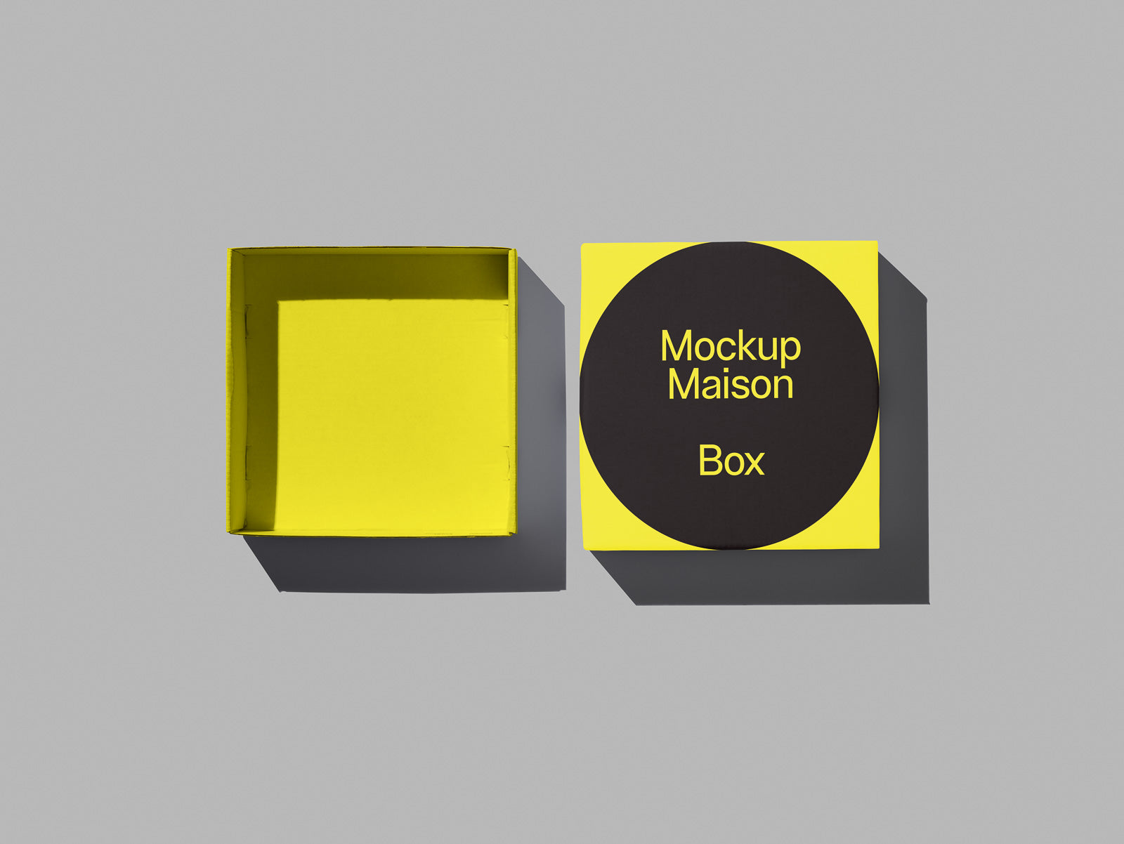 PSD mockup of an open yellow box with a flat lid featuring the text "Mockup Maison Box" on a black circle, set against a gray background.
