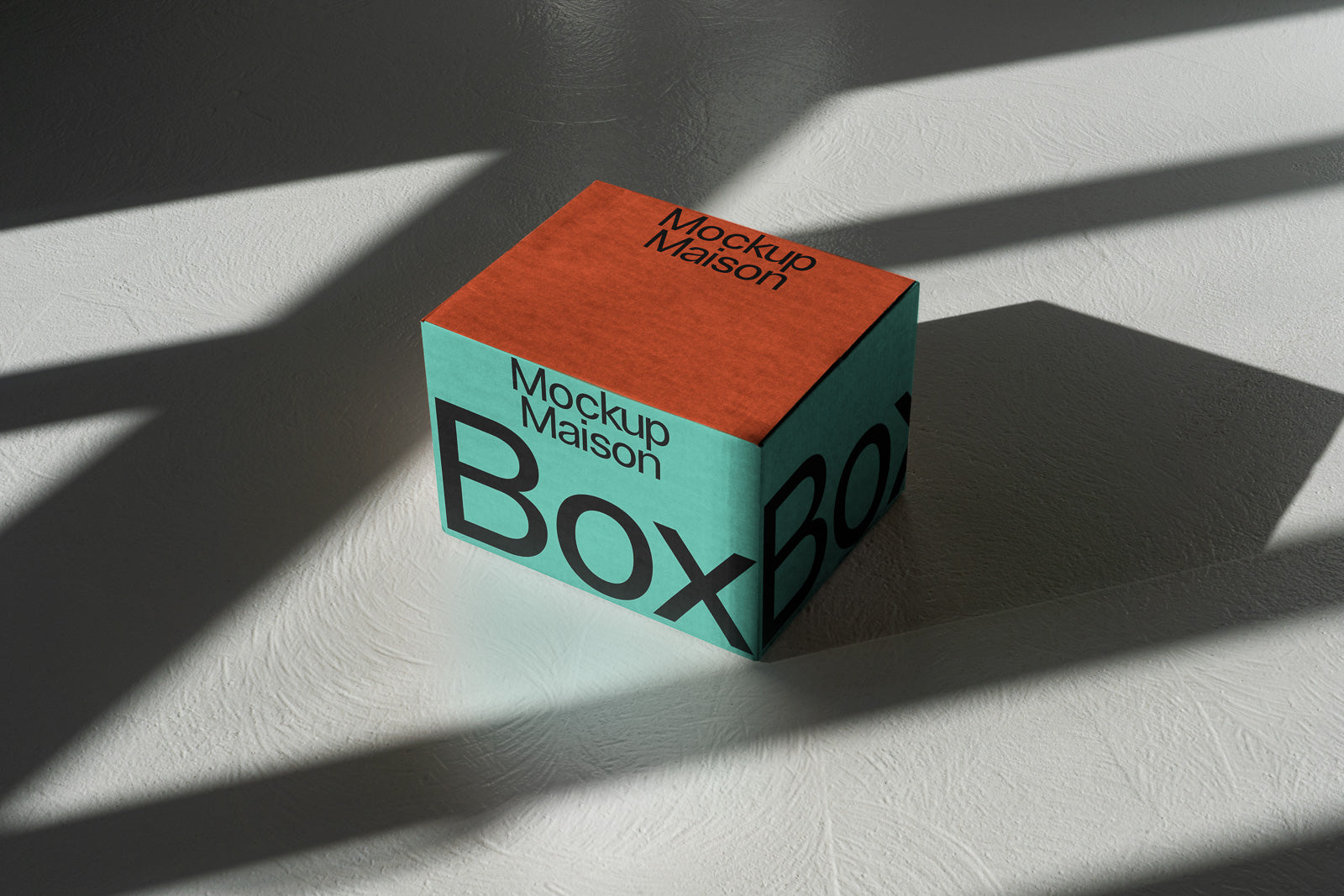 PSD mockup of a cube-shaped box with turquoise and terracotta colors, featuring the words "Mockup Maison Box" in bold text, on a textured surface.