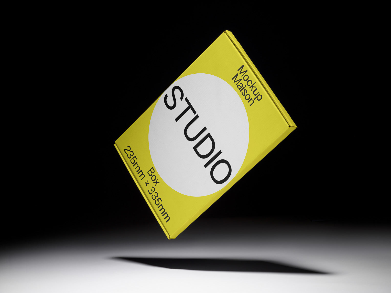 PSD mockup of a yellow box labeled "Studio," dimensions 235mm x 335mm, against a dark background, casting a shadow on a light surface.