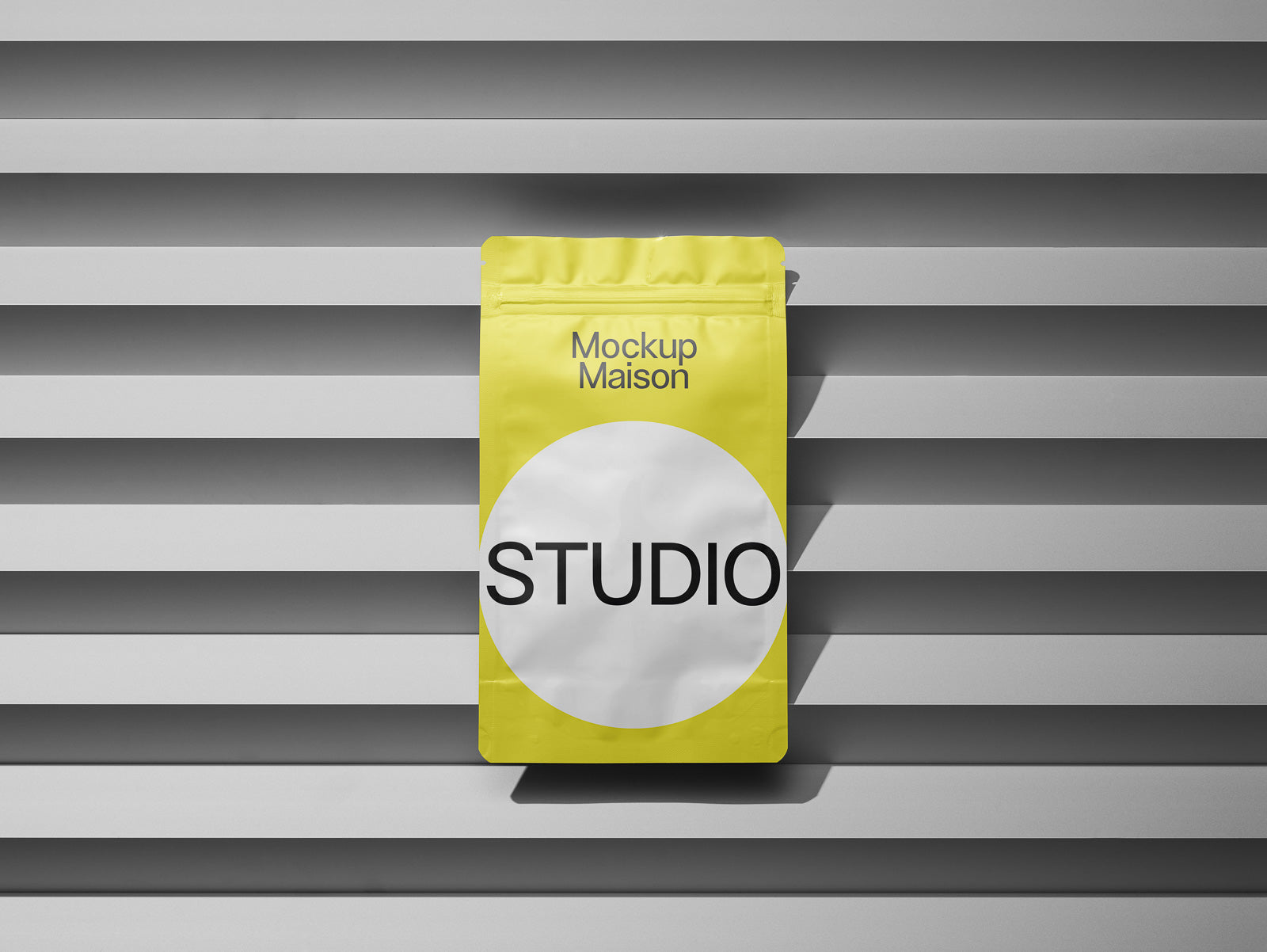 PSD mockup of a yellow stand-up pouch with "Mockup Maison" and "STUDIO" text, placed against a modern, horizontal grey panel background.