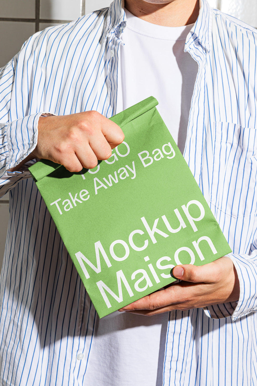PSD mockup of a green takeaway bag held by person in striped shirt, displaying bold white text including "To Go Take Away Bag" and "Mockup Maison".